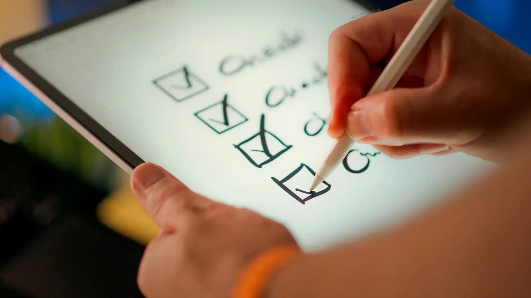 A hand ticking off items on a checklist on a tablet